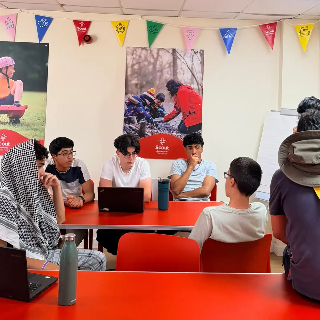Scouts discussing their ideas around a workshop table